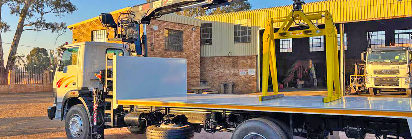 Flatbed truck fitted with a crane and Clarke Dual brick handling grab outside Clarke's Crane and Grab Sales